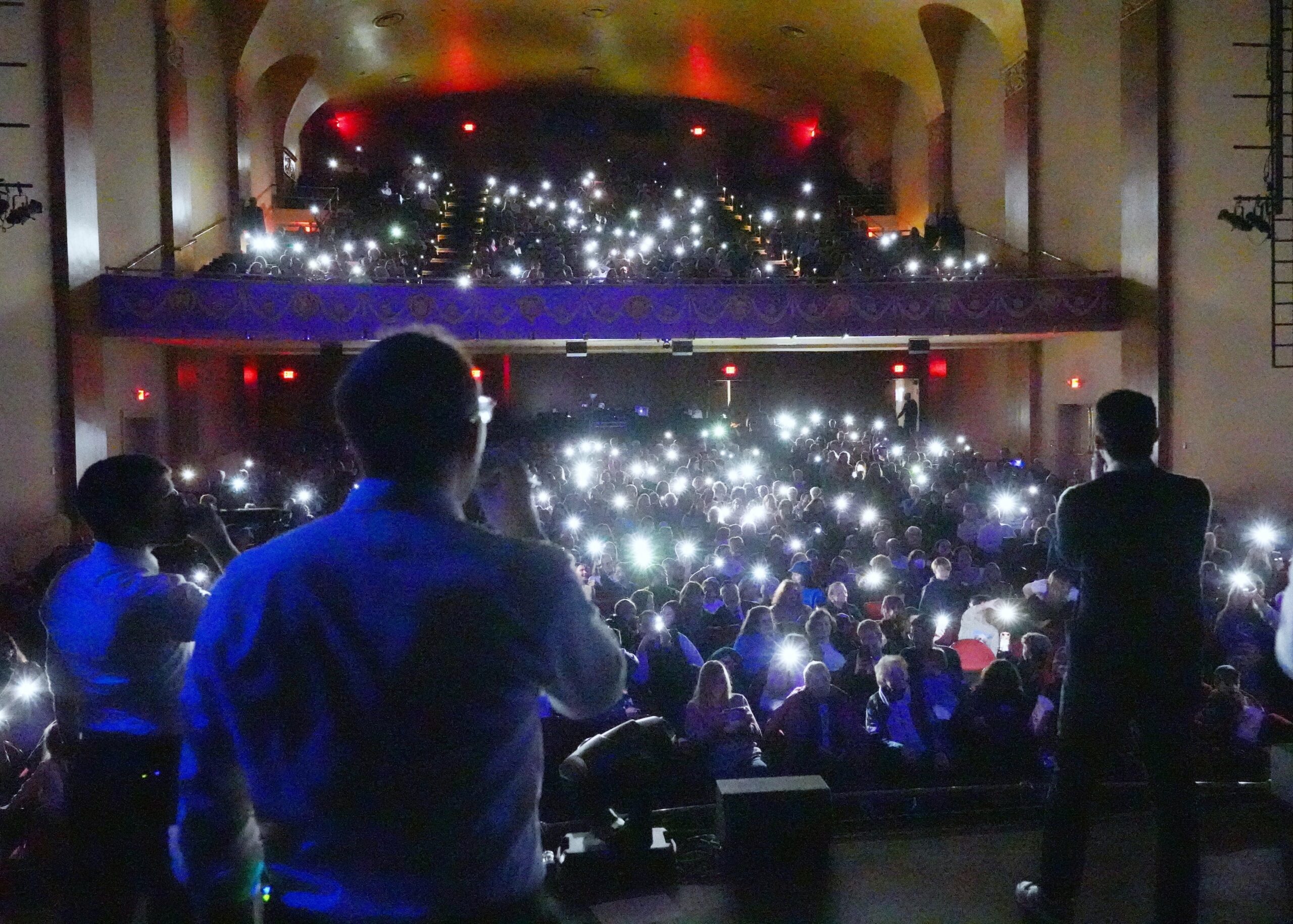 View from the stage of a concert crowd holding up phone lights